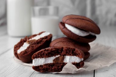 Kırık kurabiye ve kağıt üzerinde krema ile sünger çerezleri yığını. closup. Şişe ve süt lü cam ikinci planda defosused. Seçici odaklama