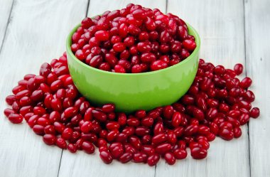 yeşil tam tabak Cornelian kiraz ve beyaz ahşap tahta üzerinde dağınık berry. Seçici odaklama