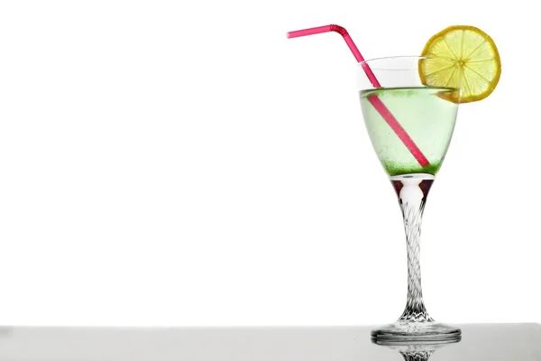 Cocktail di martini verdi in bicchiere con limone e tubule su fondo bianco — Foto Stock