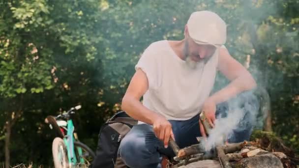 Hombre Con Barba Viajero Sienta Junto Fuego Arrojando Leña Llama — Vídeo de stock
