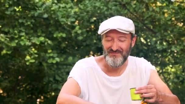 一个男人喝着热茶四处看看 夏天在森林里休息 — 图库视频影像