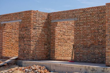 Workers are building sturdy brick walls for a new housing development project, showcasing progress in the construction industry.