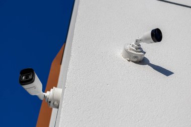 High-tech security cameras installed on a building wall ensure safety and protection through constant monitoring of the area.