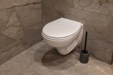 Tuvalet banyoda fayanslı zemine oturur. Duvarlar taş malzemelerle kaplı. Oda bir pencereden gün ışığında aydınlanır..