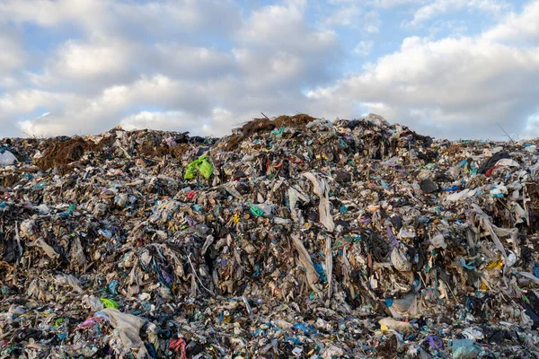 Çöp, plastik ve enkaz yığınlarıyla dolu geniş bir çöp sahası, çevre kirliliği ve atık yönetimi sorunlarını vurguluyor.