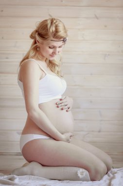 Parlak bir oda güzel hamile sarışın kadın