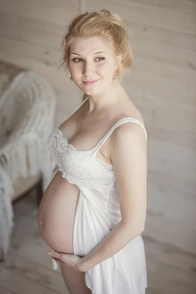 Wanita pirang hamil yang cantik di kamar yang cerah — Stok Foto