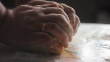 Dolly atış adam ellerin masada hamur yoğurma.