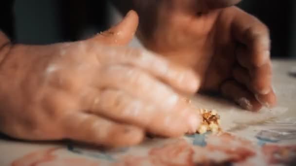 Бейкер перетворюється на долонях рук нарізаних волоських горіхів — стокове відео