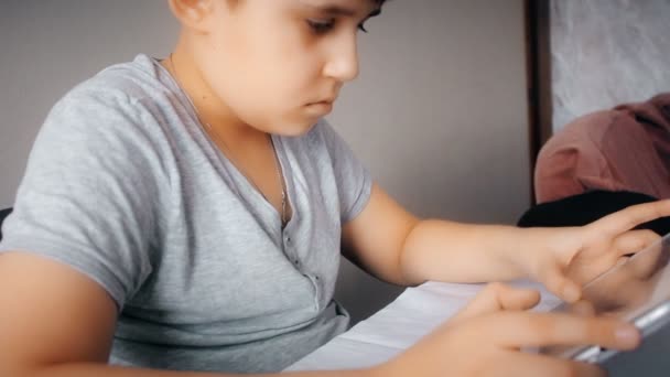 Χαριτωμένος έφηβος βλέποντας την ταινία στον υπολογιστή Tablet. Παιδί που παίζει σε ένα tablet pc. — Αρχείο Βίντεο