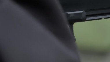 Bir el tabancayı doldurur ya da horozu çeker ve bir el ateş eder, tetiğe yakın çekim. Yüksek kalite 4k görüntü