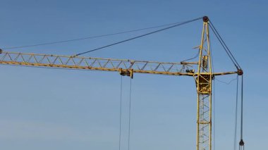 Bir inşaat vinci, çok katlı bir şantiyeye tuğla taşıyıp yüklüyor. Bir apartman inşa etme süreci. Yüksek kalite 4k görüntü