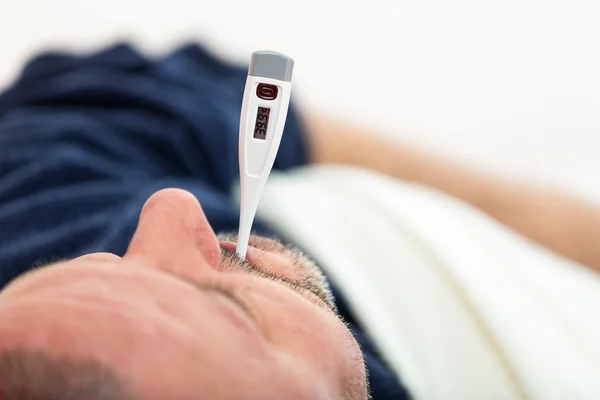 Imagem dramática de um homem doente deitado na cama com febre — Fotografia de Stock