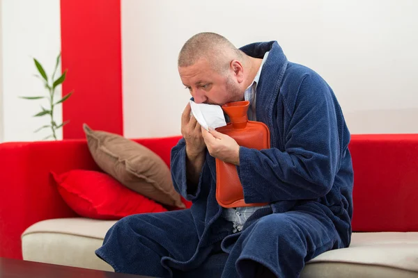 Malade au lit ayant mal à la tête tenant une bouteille d'eau chaude — Photo