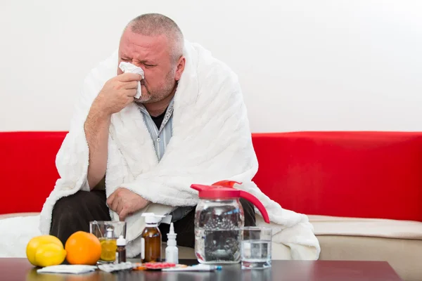 Sjuk man klädd i pyjamas lider kallt och vinter influensavirus med medicin — Stockfoto