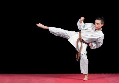 Karate çocuk izole siyah arka plan üzerine beyaz kimono mücadelede