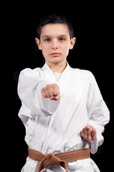 Karate boy in white kimono fighting isolated on black  background — Stock Photo, Image