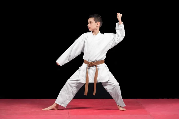 Karate boy in white kimono fighting isolated on black  background — Stock Photo, Image