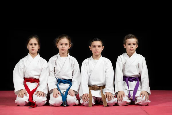 Niños en kimono sentados en tatami en el seminario de artes marciales. Enfoque selectivo —  Fotos de Stock