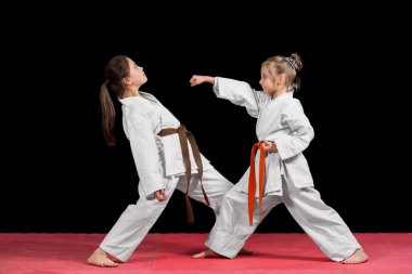 Kimono'de iki kız eşleştirilmiş egzersizleri karate eğitimi vardır