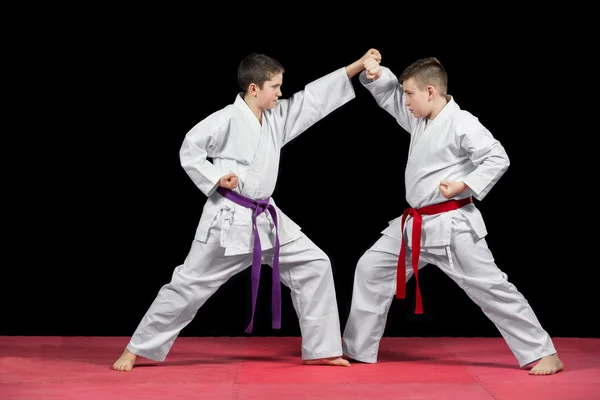 Dos chicos en kimono blanco luchando aislados sobre fondo negro —  Fotos de Stock