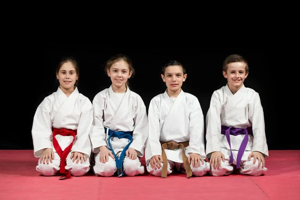 Niños en kimono sentados en tatami en el seminario de artes marciales. Enfoque selectivo —  Fotos de Stock