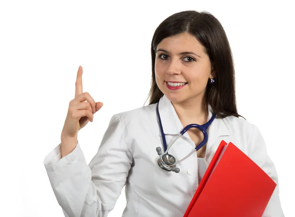 Portrait of young friendly beautiful female doctor pointing up — Stock fotografie
