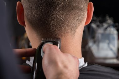 İstemciler bir elektrikli saç kesme makinesi ile saç kesme Kuaför