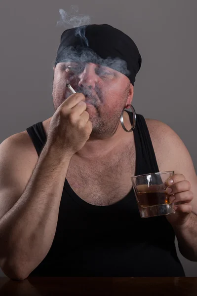 Fett pirat i svart tröja dricka alkohol — Stockfoto