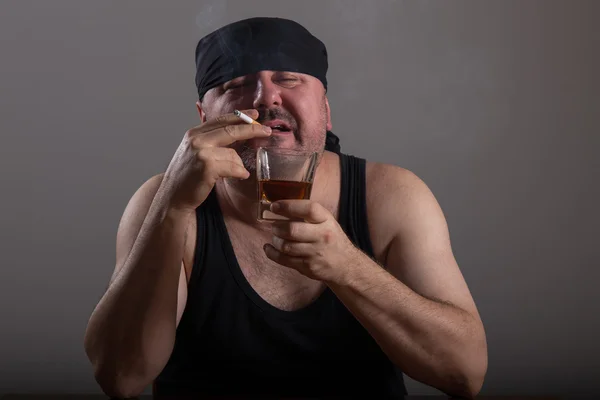Vuxen man röker cigarett och dricker whiskey — Stockfoto