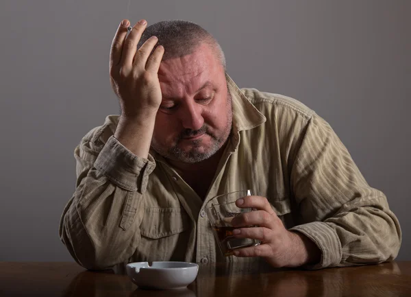 Alcoolisme : portrait d'un homme solitaire et désespéré qui boit de l'alcool et fume une cigarette — Photo