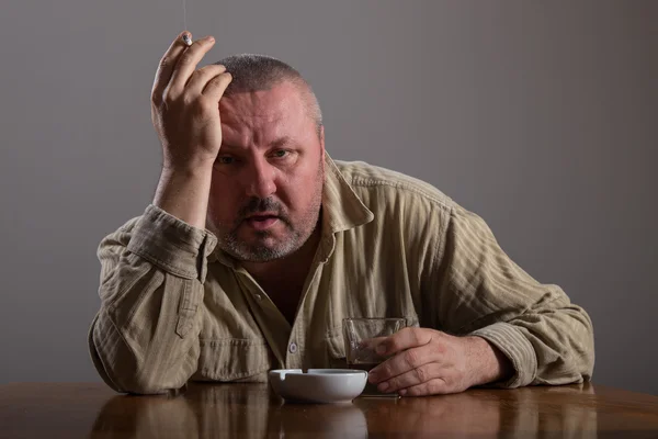 Alkoholism: porträtt av en ensam, desperat man dricka alkohol och röka cigarett — Stockfoto