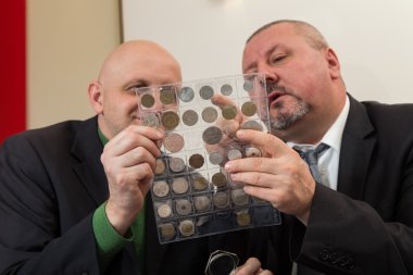 İki Bronz sikke koleksiyonu inceliyor