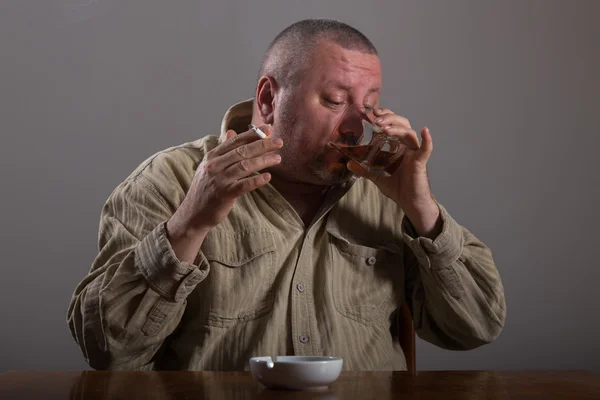 Alkoholizmus: a portré egy magányos, kétségbeesett ember ivott az alkohol és a cigaretta a dohányzás — Stock Fotó