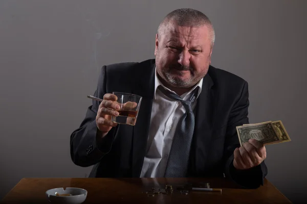 Hombre de negocios roto con un vaso de whisky y cigarrillo — Foto de Stock
