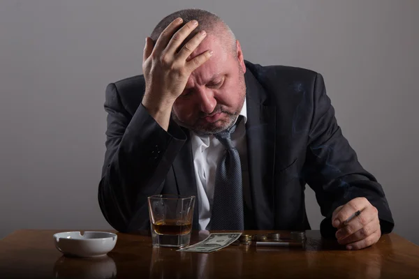 Bröt affärsman med ett glas whiskey och cigarett — Stockfoto