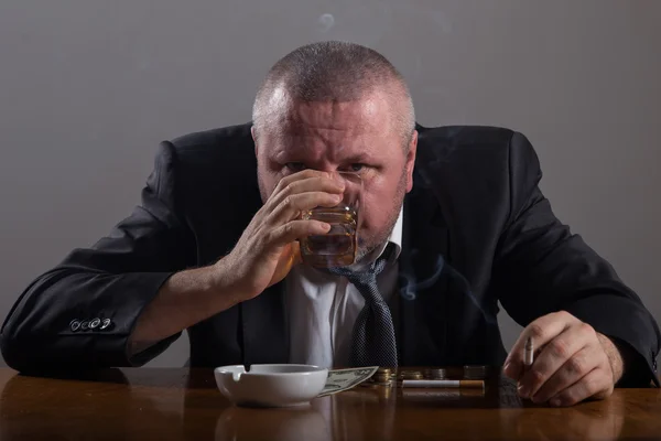 Hombre de negocios roto con un vaso de whisky y cigarrillo — Foto de Stock