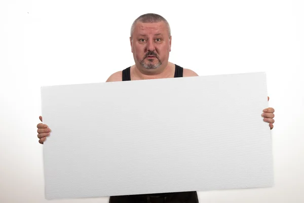 Occasionnel gros homme tenant un papier vierge sur un fond blanc — Photo