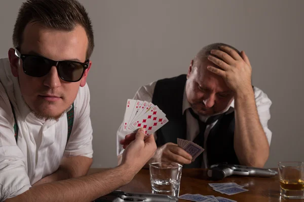 Joven y hombre de negocios jugando póquer con armas — Foto de Stock