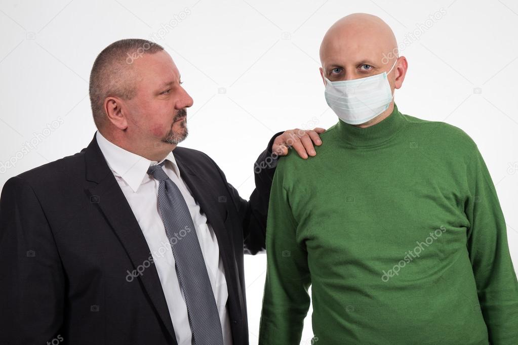 Businessman comforting young man suffering from cancer