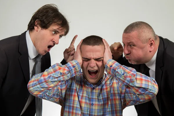 Young man being yelled at by two senior male manager on white — Stock Photo, Image