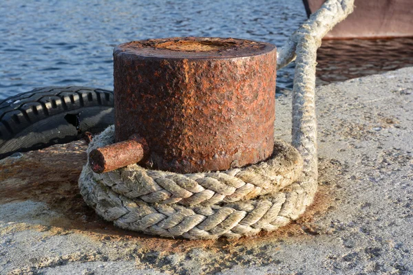 Bollard de amarração enferrujado com cordas de navio na doca — Fotografia de Stock