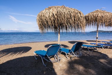 Saman şemsiye ve şezlong üzerinde bir kumsalı, Corfu, Yunanistan