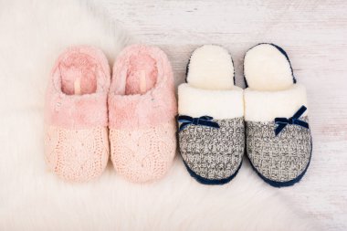 Beyaz kürklü halıda iki çift sıcak kadın terliği..