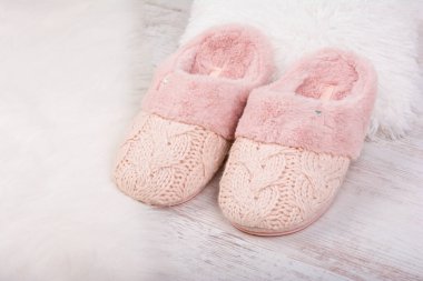 Beyaz tüylü halıda bir çift sıcak kadın terliği..