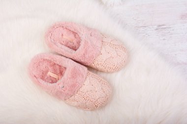 Beyaz tüylü halıda bir çift sıcak kadın terliği..