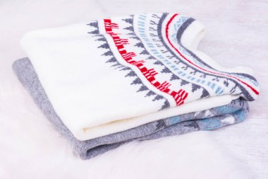 Sıcak kış örgü süveterler beyaz rahat arka planda.