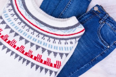 Sıcak kış örgü süveter ve beyaz rahat arka planda mavi kot pantolon.