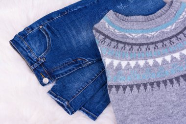 Sıcak kış örgü süveter ve beyaz rahat arka planda mavi kot pantolon.