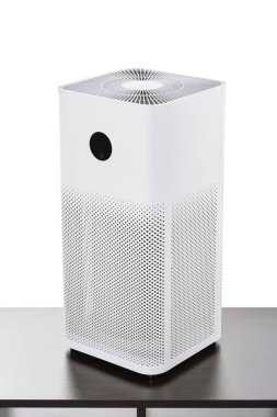 İnce tozları temizlemek için filtreli hava temizleyici PM2.5 kokular ve siyah bir masanın üzerinde duran, kırpma yolu beyaz arkaplanda izole edilmiş duman.